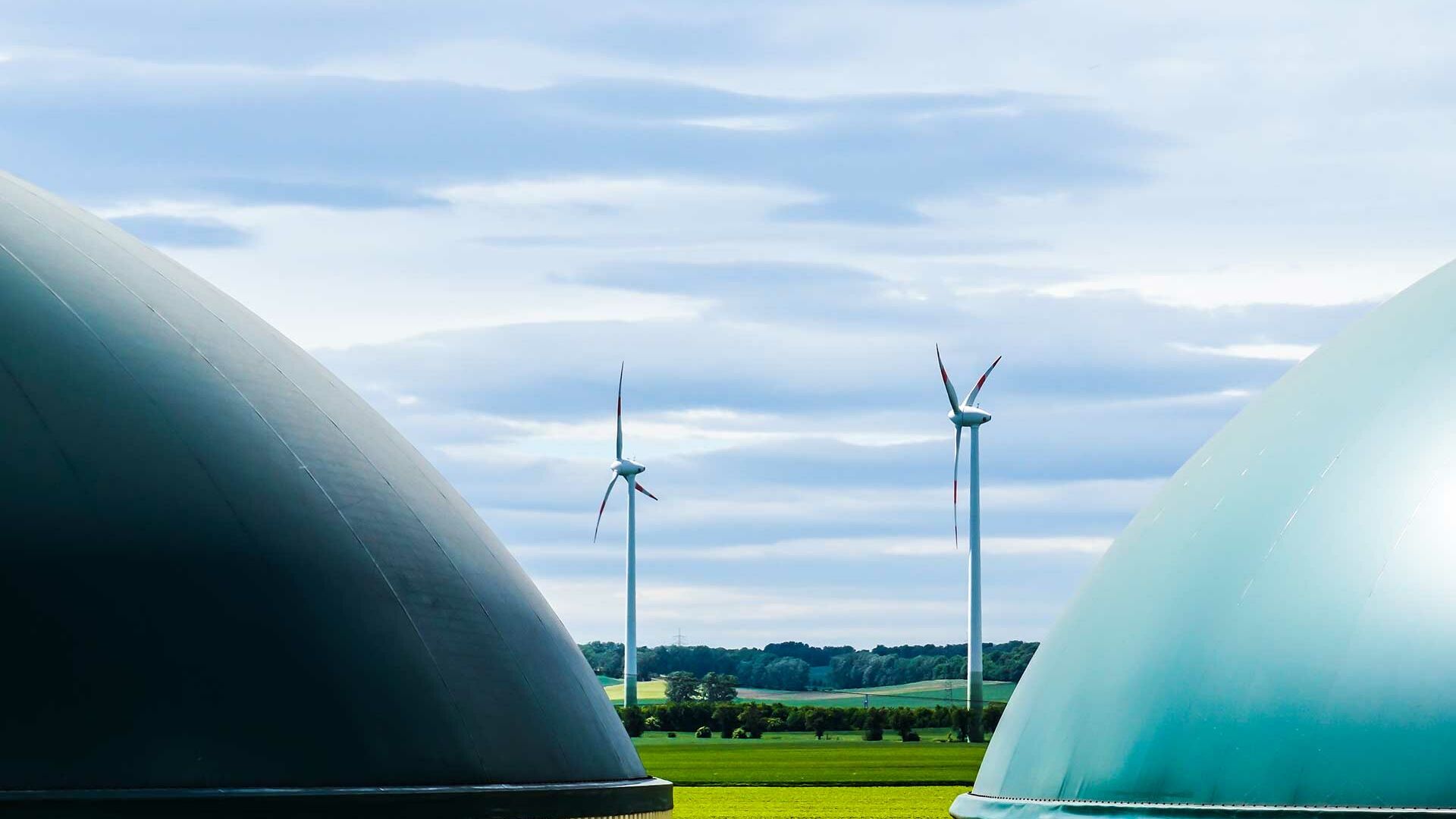 Biokraftwerk und Windräder als Bestandteile der Energiewirtschaft.