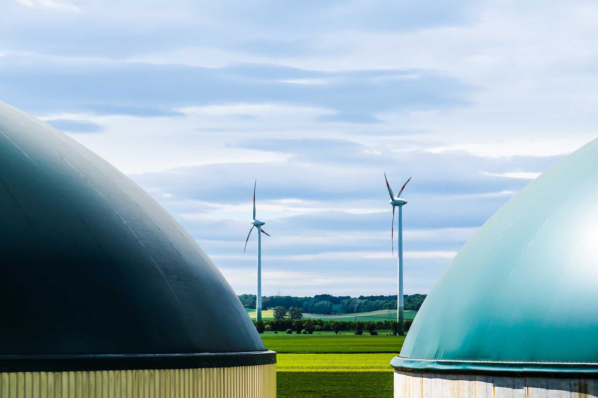 Biokraftwerk und Windräder als Bestandteile der Energiewirtschaft.